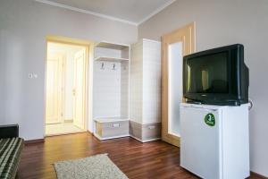 a living room with a tv on top of a refrigerator at Tulipan Hotel Aquapark in Vyshkove