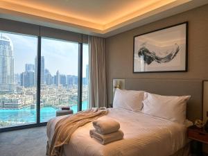 a bedroom with a bed and a large window at Luxury 3-bedroom apartment with a stunning view of the Burj Khalifa and the Fountain in Dubai