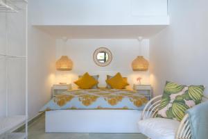 a bedroom with a bed with yellow pillows and a chair at Holiday house Casa Mariposa in Tabayesco in Tabayesco
