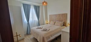 a bedroom with a large bed with blue curtains at Blue Lagoon Apartment in Costa Calma