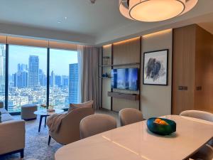 a living room with a table and chairs at Luxury 3-bedroom apartment with a stunning view of the Burj Khalifa and the Fountain in Dubai