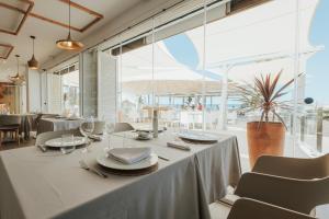 una sala da pranzo con tavolo, sedie e finestre di Kampaoh Kikopark Playa a Oliva