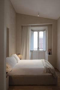 a bedroom with a large white bed with a window at P10 DESIGN in Rome