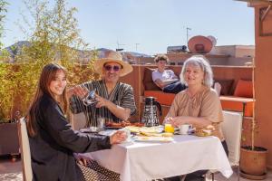 マラケシュにあるRiad Ushuaia La Villa - Centre Marrakechの食卓に座って食べる人々