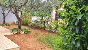 a garden with two trees and a fence at Apartments Cintya in Poreč