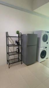 een wasruimte met een wasmachine en een wasmachine bij R&R Manjung Guest House at Pangsapuri Samudera in Seri Manjung