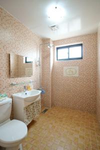 La salle de bains est pourvue de toilettes, d'un lavabo et d'une fenêtre. dans l'établissement Heng Bin Bed and Breakfast, à Taïtung