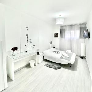 una camera da letto bianca con un letto e uno specchio di Domus Euclide a Roma