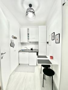 una cucina bianca con tavolo e due sedie di Domus Euclide a Roma