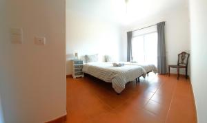 a bedroom with a bed and a large window at Beach House Espartal - Monte Clerigo - Aljezur in Vales
