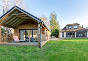 a log cabin with a deck and a house at Haons in Biddenden