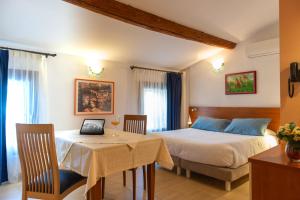 sypialnia z 2 łóżkami, stołem i krzesłami w obiekcie B&B La Casa di Rosa w mieście Vago