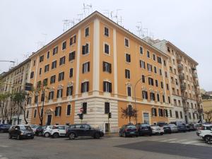 a large yellow building with cars parked in front of it at Delizioso appartamento al Pigneto in Rome