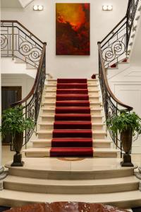 a staircase with a red rug on the stairs at InterContinental Rome Ambasciatori Palace, an IHG Hotel in Rome
