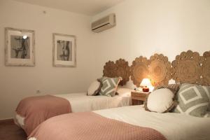 a bedroom with two beds with a mirror on the wall at Casa Tekas - Centro Ciudad in Caravaca de la Cruz
