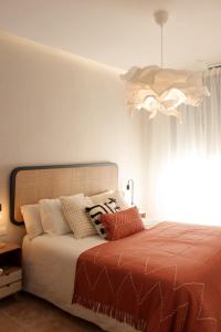 a bedroom with a bed and a chandelier at Casa Tekas - Centro Ciudad in Caravaca de la Cruz