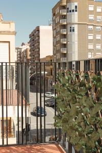 ein Baum auf einem Balkon mit Gebäuden im Hintergrund in der Unterkunft Casa Tekas - Centro Ciudad in Caravaca de la Cruz