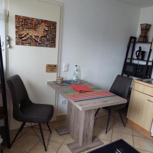 cocina con mesa de madera y 2 sillas en Ottilienhof, en Schwaigern
