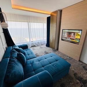 un divano blu in una stanza con una grande finestra di STEAUA DE MARE - Olimp Resort a Olimp