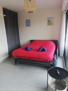 een rood bed met twee teddyberen erop in een kamer bij Charmant studio au calme in Thonon-les-Bains