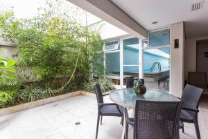 a patio with a table and chairs and a garden at Igloo Vila Olímpia in Sao Paulo