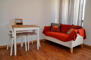 een woonkamer met een bank, een tafel en een stoel bij Alboi Loft in Aveiro