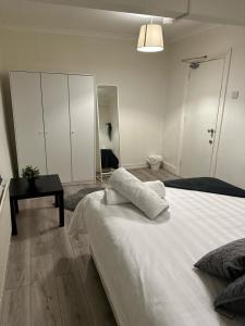 a bedroom with a large white bed and a mirror at Spacious 4 bedroom house in the city of London in London