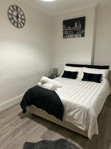 a bedroom with a large bed with a clock on the wall at Spacious 4 bedroom house in the city of London in London
