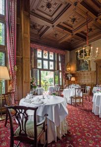 un comedor con mesas y sillas y una lámpara de araña en Schlosshotel Kronberg - Hotel Frankfurt, en Kronberg im Taunus