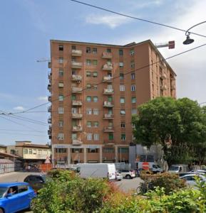 a tall building with cars parked in a parking lot at Grand Central - Affitti Brevi Italia in Modena