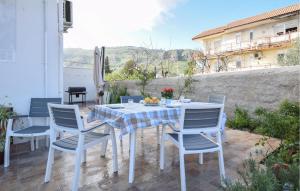 a white table and chairs on a patio at Awesome Apartment In Portella Di Mare With Kitchen in Portella di Mare