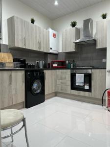 una cucina con lavatrice, piano cottura e lavastoviglie di Spacious 4 bedroom house in the city of London a Londra