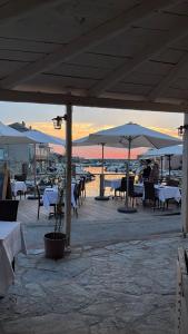 a group of tables and umbrellas on a beach at L’Auberge du pêcheur in Centuri