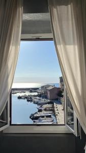 a window in a room with a view of a marina at L’Auberge du pêcheur in Centuri