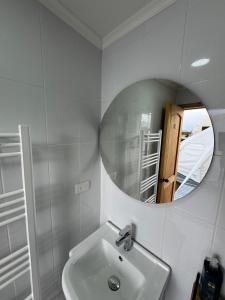 een witte badkamer met een wastafel en een spiegel bij Chilenativo Riverside Camp in Torres del Paine