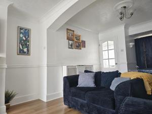 a living room with a blue couch and a window at Orpington North Townhouse in Orpington