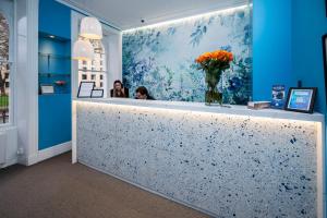 two women sitting at a counter in a room with blue walls at Mentone Hotel in London