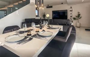 uma mesa de jantar com uma toalha de mesa branca e cadeiras em Awesome Home In Vodnjan With Wi-fi em Vodnjan