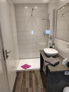 a bathroom with a sink and a shower at Hotel Stock Teekännle in Friedrichshafen