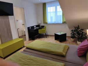 a room with two beds and a desk in it at Hotel Stock Teekännle in Friedrichshafen