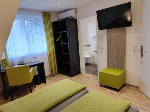 Habitación con cama, escritorio y TV. en Hotel Gästehaus Stock Zimmer Kaffeesäckle en Friedrichshafen