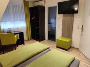 Zimmer mit 2 Betten, einem Schreibtisch und einem TV in der Unterkunft Hotel Gästehaus Stock Zimmer Kaffeesäckle in Friedrichshafen