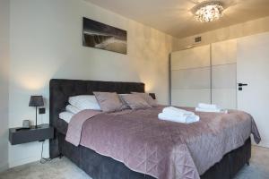 a bedroom with a bed with towels on it at Apartament Premium PINEA 313 in Pobierowo