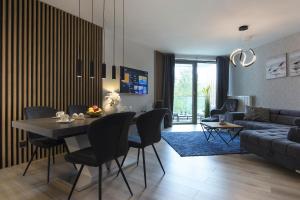 - un salon avec une table, des chaises et un canapé dans l'établissement Apartament Premium PINEA 313, à Pobierowo