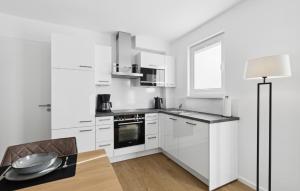 a kitchen with white cabinets and a table and a lamp at Sonnendeck in Winterberg