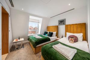 a bedroom with two beds and a window at Marble Arch Penthouse 2 Bed in London