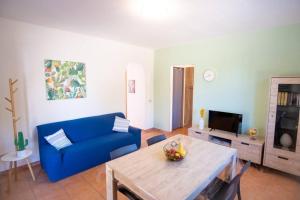 a living room with a blue couch and a table at Villa Indipendente Jacuzzi Giardino Clima WiFi in Castellammare del Golfo