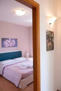a bedroom with a bed with a blue headboard at Villa Indipendente Jacuzzi Giardino Clima WiFi in Castellammare del Golfo