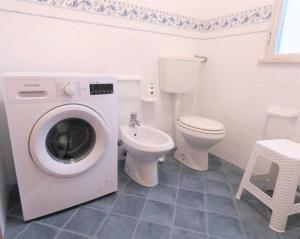 a bathroom with a washing machine and a toilet at Villa Indipendente Jacuzzi Giardino Clima WiFi in Castellammare del Golfo