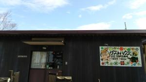 a sign on the side of a black building at Guesthouse MI CASA SU CASA in Zentsuji